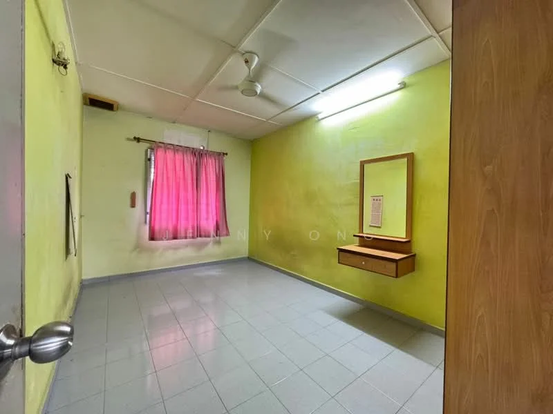 Room features: green painted walls, grey tiled flooring, ceiling fan, window with pink curtains, wall-mounted mirror with shelf, light fixture on ceiling, single door, no visible furniture.