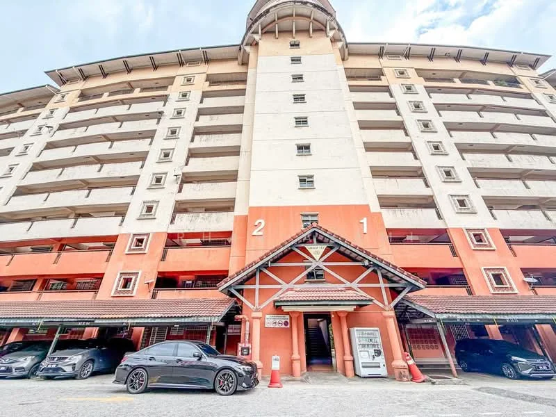 Exterior type: low-rise apartment block; features: multi-storey building, orange and white painted facade, covered parking area, entrance with awning, visible car parking, staircase leading to entrance, balconies on upper floors, decorative roof structure; style: traditional.