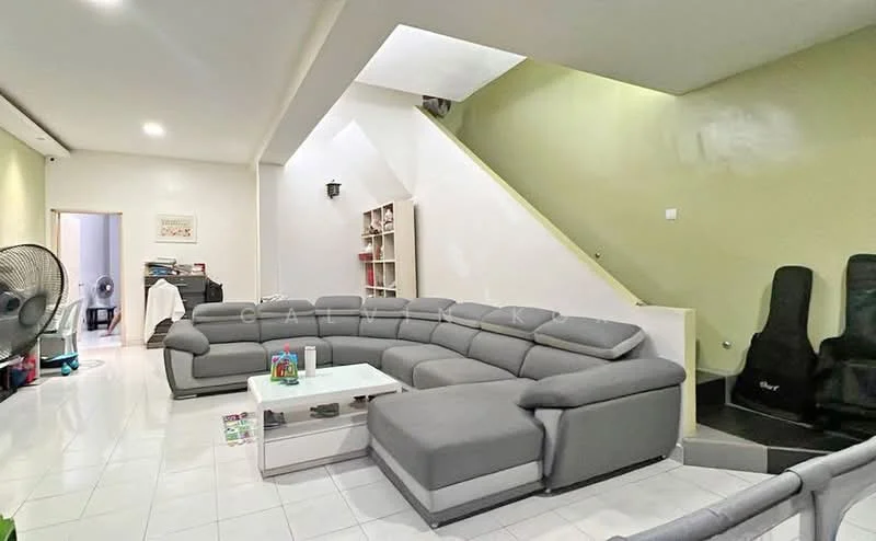 Living features: L-shape sectional sofa in grey, coffee table, white tiled flooring, green accent wall, white painted walls, built-in shelving unit, ceiling fan, staircase leading to upper level, decorative items on shelves, two black gaming chairs; style: modern.