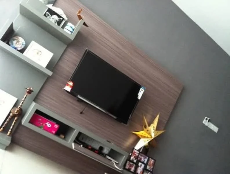 Living features: wall-mounted TV, wood feature wall, grey accent wall, floating shelves, decorative items on shelves, framed photos, star-shaped decor, giraffe figurine; style: modern.