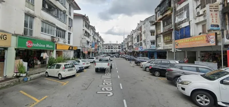 Exterior type: shophouse; features: two-storey shophouses, mixed-use commercial and residential, signage on buildings, street parking, pedestrian walkway, multiple storefronts, urban street view, cars parked along the street; style: traditional.