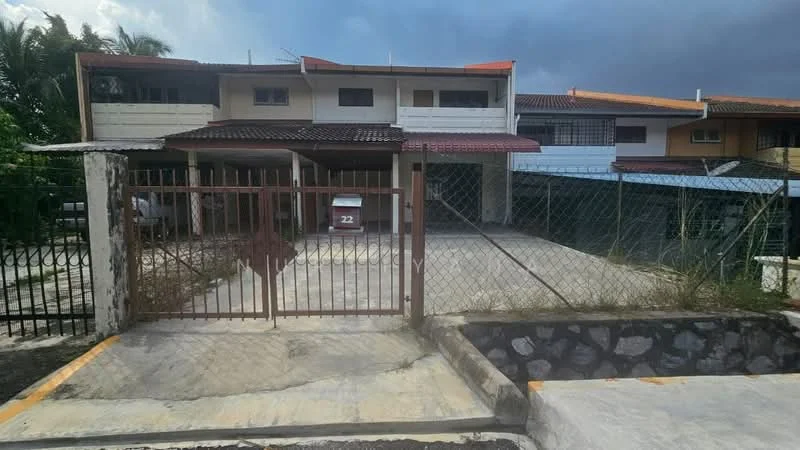 Exterior type: linked terrace house; features: gated entrance, fenced yard, paved driveway, two-storey building, red tiled roof, white painted facade, balcony on upper floor, manicured lawn, surrounded by greenery; style: modern.
