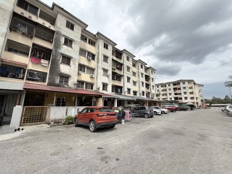 Exterior type: low-rise apartment block; features: multiple storeys, balconies with railings, exposed concrete facade, parking lot with multiple vehicles, manicured landscaping, surrounding greenery, entrance with gate, outdoor space for residents; style: modern.