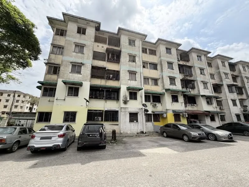 Exterior type: low-rise apartment block; features: white painted facade, green awnings over windows, balconies with metal railings, multiple air conditioning units visible, parking lot with several cars, two-storey building, exposed concrete surfaces, surrounded by trees; style: traditional.