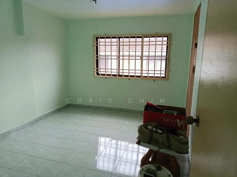 Room features: light green painted walls, white tiled flooring, wooden window with grid pattern, natural light from window, single door, empty space, no visible furniture, corner of the room with a small table.