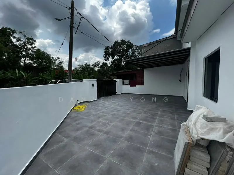 Exterior features: grey tiled flooring, white painted walls, overhead awning, exposed electrical wiring, landscaped greenery in background, concrete boundary wall, outdoor space with ample natural light; style: modern.