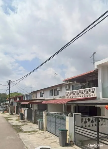 Exterior type: linked terrace house; features: two-storey linked terrace, red tiled roof, white painted facade, balcony with railing, multiple antennas on roof, driveway with interlocking pavers, garbage bins visible, fenced front yard, street view with power lines, manicured lawn in front; style: modern.