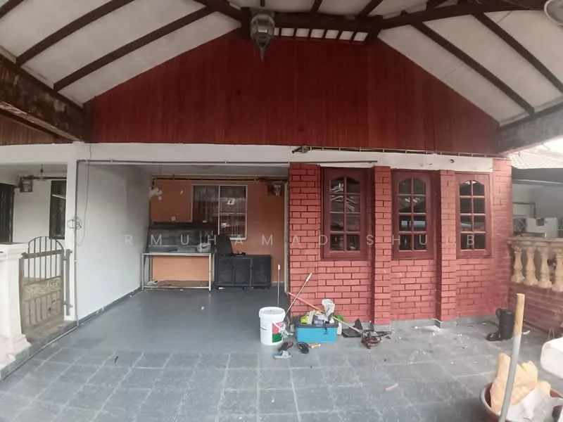Room features: exposed wooden beams on ceiling, red brick wall, white painted walls, grey tile flooring, multiple windows with wooden frames, open layout, kitchen area with countertop, unfinished decor items, outdoor access, light fixture hanging from ceiling; style: traditional.