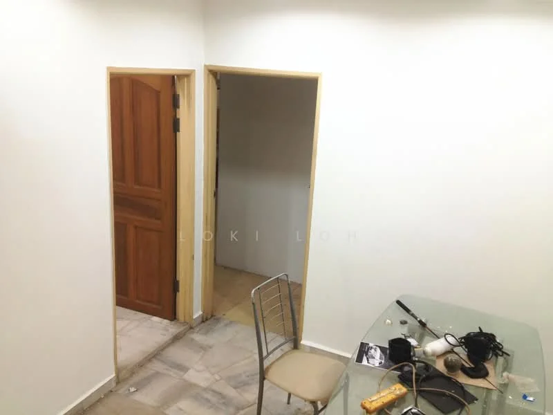 Room features: white painted walls, marble flooring, wooden door, metal chair, glass dining table, visible electrical wires, doorway leading to another room.