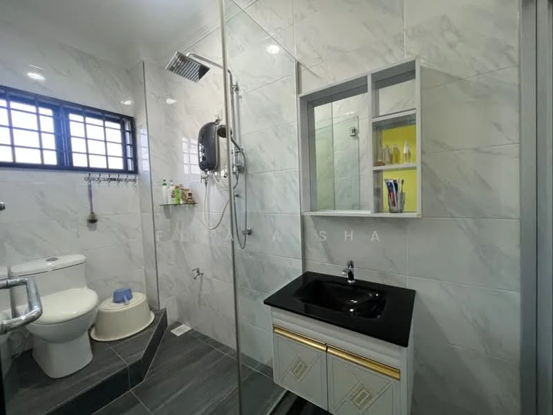 Bathroom features: white ceramic toilet, walk-in shower with glass enclosure, chrome rain shower head, chrome handheld shower, black countertop with under-mount sink, gold cabinet with two drawers, grey marble tile walls, grey tile flooring, mirror with shelf, window with grid pattern, shower caddy, wall-mounted soap dispenser; style: modern.