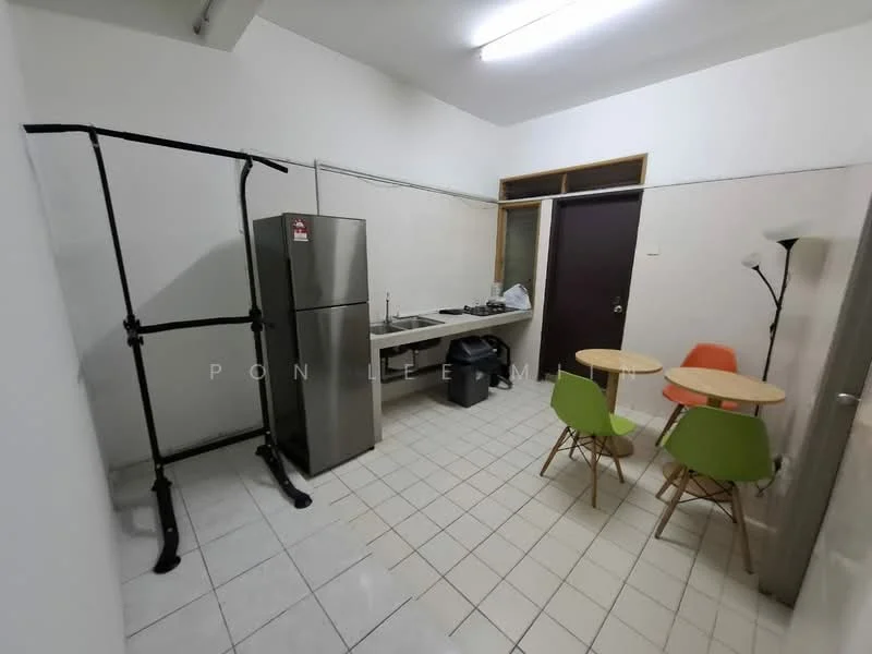 Kitchen features: stainless-steel fridge, kitchen countertop, gas stove, wall-mounted cabinets, white tiled walls, white tiled flooring, two small dining tables, green and orange chairs, floor lamp, clothes rack.