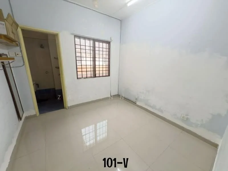 Room features: white painted walls, glossy tile flooring, single window with metal grille, ceiling light fixture, built-in shelf, corner wall with plumbing fixtures, neutral color scheme.