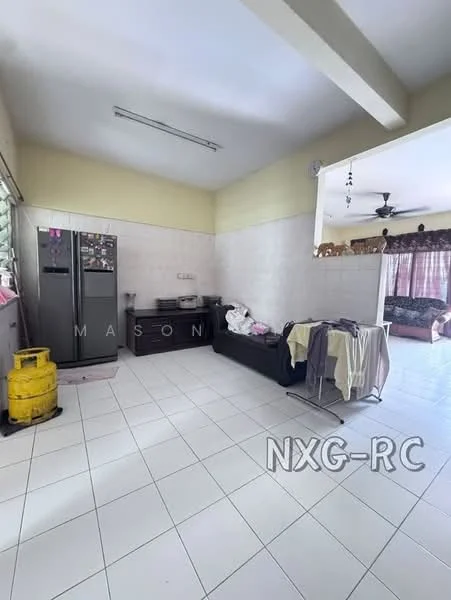 Kitchen features: white tiled walls, white tiled flooring, stainless-steel fridge, black wooden cabinet, ceiling fan, window with metal grille, sink, laundry basket, clothes on sofa. Living features: sofa, curtains, coffee table.