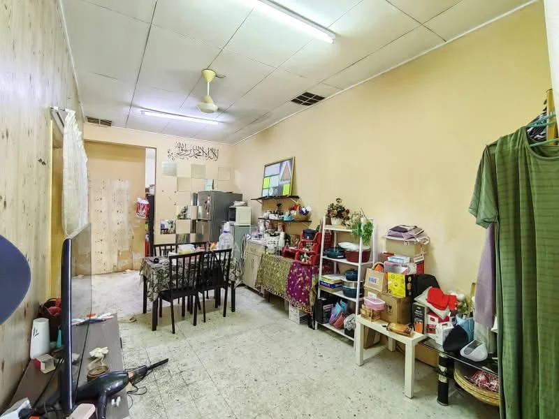 Room features: cream painted walls, concrete flooring, ceiling fan, dining table with four chairs, kitchenette with sink, small refrigerator, open shelving, various storage boxes, decorative items on shelves, wall-mounted artwork, multiple light fixtures, clothes rack, area rug.