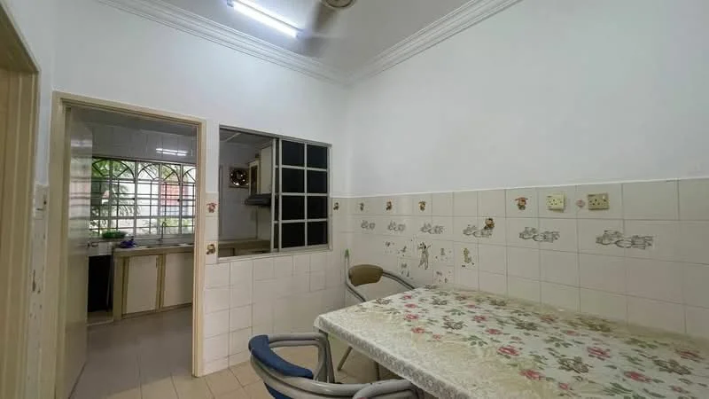 Dining features: white painted walls, tile flooring, dining table with floral tablecloth, two dining chairs, wall-mounted electrical outlets, decorative wall tiles, window with grid pattern, doorway leading to kitchen. Kitchen features: white cabinetry, tile backsplash, window with grid pattern, doorway leading to dining area.