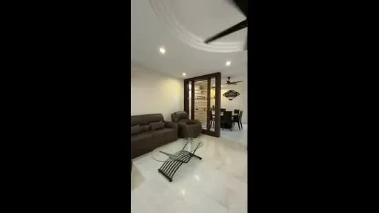 Living features: 3-seater fabric sofa in grey, 2-seater fabric sofa in grey, coffee table, marble flooring, ceiling fan, recessed downlights, decorative wall art, sliding glass door, wooden door with slatted design, dining area visible in background; style: modern.