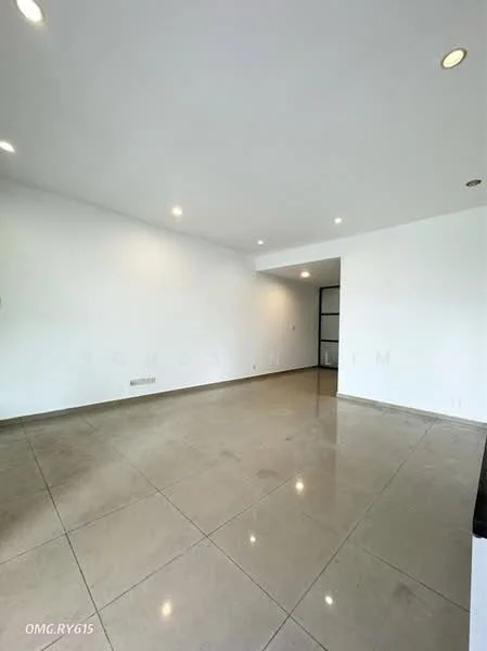 Room features: white painted walls, polished ceramic tile flooring, recessed downlights, large open space, no visible furniture, neutral color scheme, smooth ceiling, corner with glass door; style: modern.