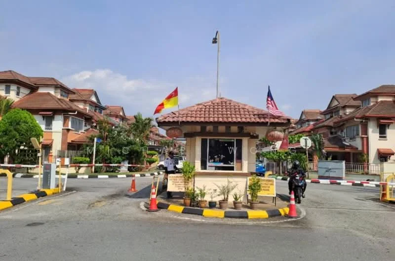 Exterior type: gated community entrance; features: guard house at entrance, paved driveway, traffic barrier, landscaped greenery, flag poles with flags, surrounding residential buildings, manicured lawn, palm trees, street signage, security intercom panel; style: modern.