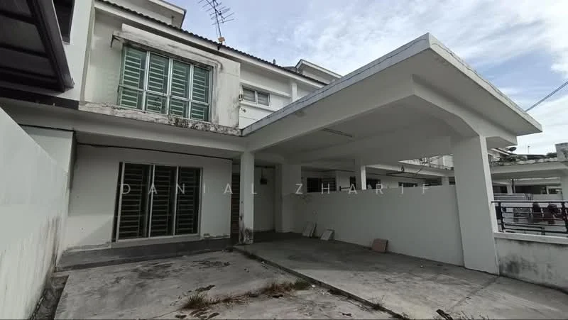 Exterior type: semi-detached house; features: flat roof, white painted facade, green louvered windows, concrete driveway, covered car porch, exposed concrete walls, surrounding wall, outdoor space with debris, satellite dish on roof; style: modern.