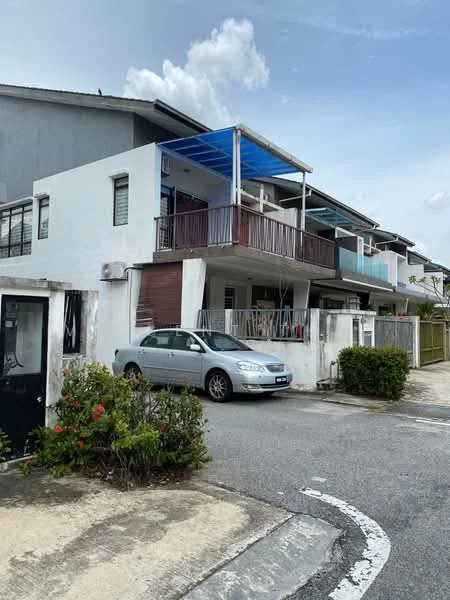 Exterior type: linked terrace house; features: white painted facade, blue awning over balcony, balcony with railing, ground-level parking space, manicured shrubs in front, two-storey structure, visible air conditioning unit, concrete driveway, surrounding greenery; style: modern.