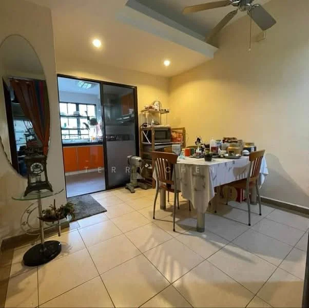 Dining features: round dining table, 4 wooden dining chairs, white tablecloth, ceiling fan, tiled flooring, wall-mounted mirror, decorative plant on stand, open access to kitchen, orange cabinetry visible through doorway, window with natural light.