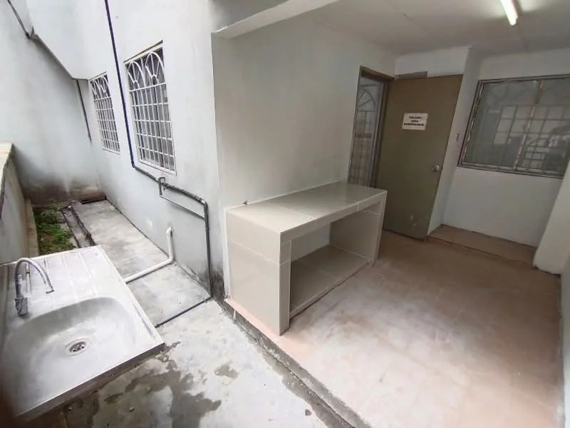 Laundry features: single-bowl stainless-steel sink, grey countertop, white painted walls, tile flooring, window with metal grille, door to exterior, exposed plumbing, light fixture on ceiling.