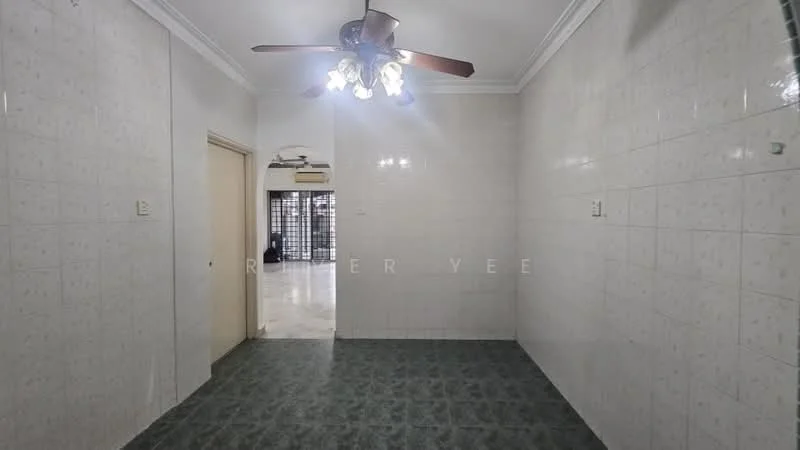Room features: white tiled walls, green patterned vinyl flooring, 5-blade ceiling fan with light, doorway leading to another room, wall-mounted air conditioning unit, light fixture with multiple bulbs, no visible furniture, neutral color scheme.