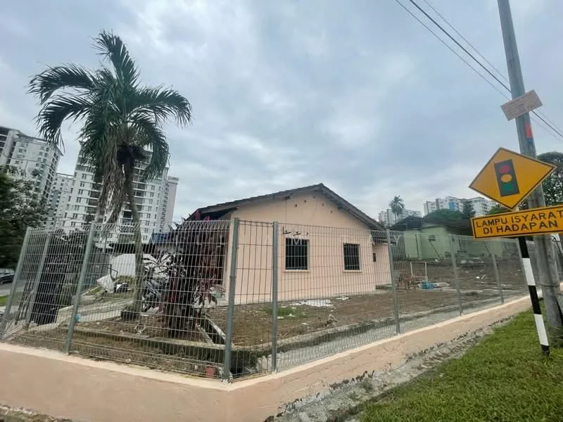 Exterior type: detached bungalow; features: pink painted facade, single-storey, fenced perimeter, manicured lawn, palm tree in front yard, surrounded by residential buildings, roadside view, traffic sign visible; style: traditional.