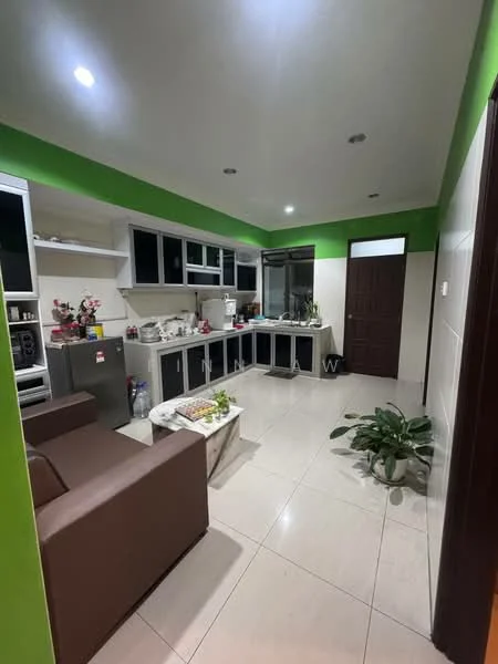 Kitchen features: green accent wall, white painted walls, ceramic tile flooring, L-shaped kitchen layout, black cabinetry, stainless-steel fridge, built-in oven, freestanding range oven, double-bowl stainless-steel sink, chrome pull-down faucet, window above sink, countertop with decorative items, potted plant, recessed downlights, open shelving; style: modern. Living features: brown leather sofa, coffee table, decorative items on table; style: modern.