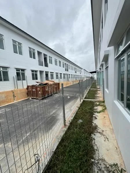 Exterior type: linked terrace house; features: white painted facade, two-storey buildings, fenced perimeter, asphalt road, construction debris, landscaped grass area, windows with metal grilles; style: modern.