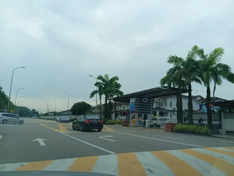 Exterior type: gated community; features: guard house at entrance, palm trees, manicured landscaping, two-storey residential buildings, wide access road, street lighting, traffic markings, surrounding greenery; style: modern.
