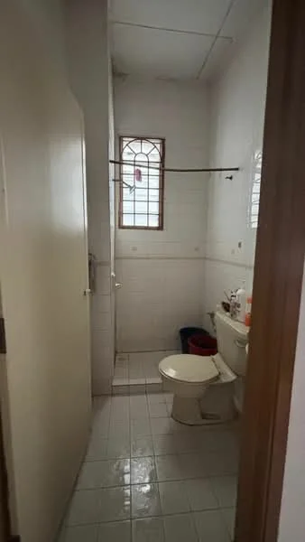 Bathroom features: white tiled walls, white ceramic floor tiles, toilet, sink with faucet, shower area, window with grille, mirror above sink, towel rack.