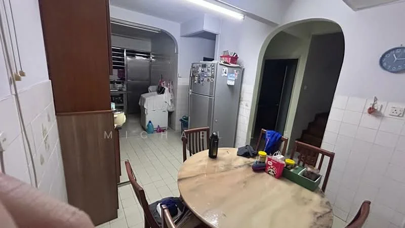 Kitchen features: white tiled walls, cream tiled flooring, round dining table, wooden dining chairs, stainless-steel fridge, built-in cabinetry, kitchen counter, open layout to living area, wall-mounted clock.