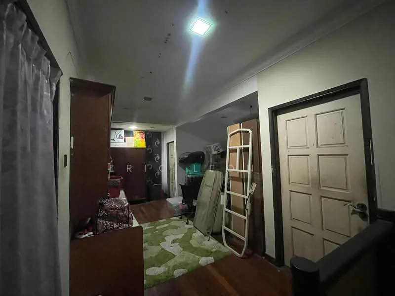 Room features: wood flooring, white painted walls, ceiling light, door with panel design, green area rug, wooden cabinets, folding chair, clothes rack, decorative wall art.