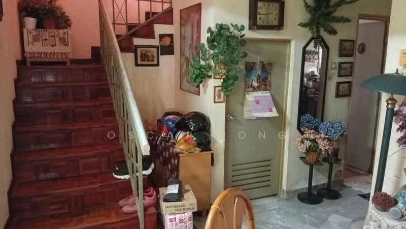 Room features: wooden staircase, parquet wood flooring, cream painted walls, decorative wall plants, framed artwork on walls, wall clock, door with vent, various decorative items, table lamp, potted flowers, shoe storage, boxes, seating area with chairs; style: traditional.