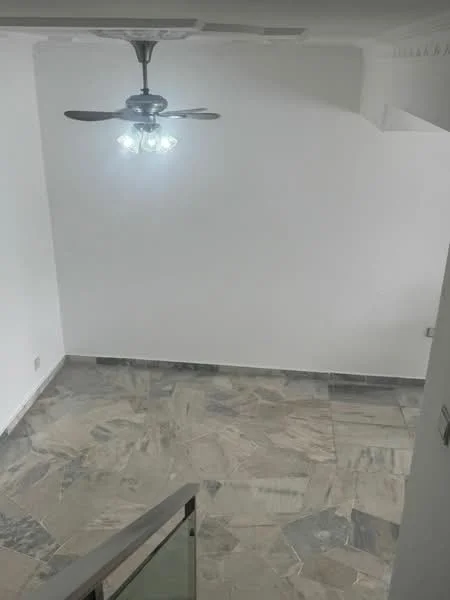 Room features: marble tile flooring, white painted walls, ceiling fan with light, recessed lighting, staircase railing, corner wall with electrical outlet.