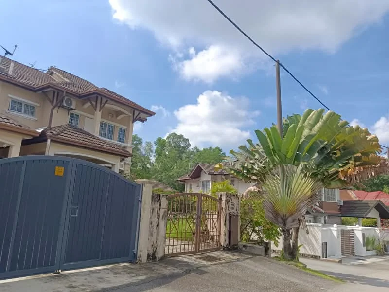 Exterior type: semi-detached house; features: grey painted gate, two-storey house, brown tiled roof, cream painted facade, wooden accents, manicured lawn, tropical landscaping with palm trees, surrounded by greenery, paved driveway, visible air conditioning units; style: modern.