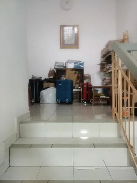 Room features: white painted walls, tile flooring, staircase with railing, wooden shelving unit, various boxes and bags, framed artwork on wall, natural light from window.