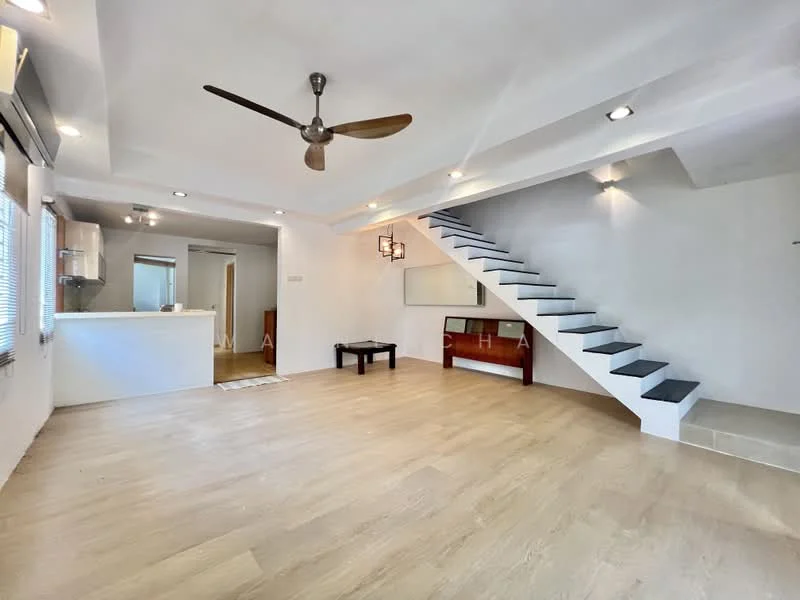 Living features: light wood flooring, white painted walls, recessed downlights, 5-blade ceiling fan, open-plan layout, staircase with black steps, large windows with blinds, wall-mounted TV console, decorative wall panel, neutral color scheme; style: modern. Kitchen features: kitchen island, white cabinetry, stainless-steel appliances, open to living area; style: modern.