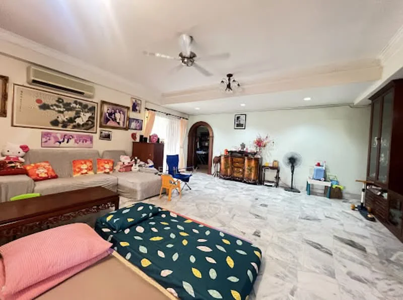 Living features: marble tile flooring, white painted walls, 5-blade ceiling fan with light, sofa with colorful cushions, wooden coffee table, wooden sideboard, decorative wall art, floor fan, large window with sheer curtains, area rug with leaf pattern, children's chair, stuffed toys on sofa; style: traditional.