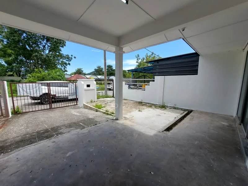 Exterior features: concrete flooring, white painted walls, gated entrance, landscaped area, open space, surrounded by greenery, driveway, partially covered area; style: modern.