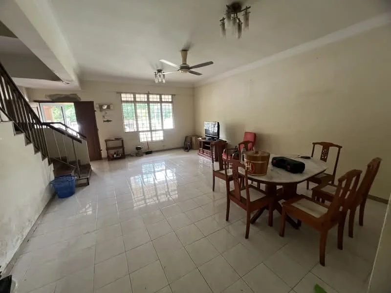 Living features: white painted walls, polished ceramic tile flooring, 5-blade ceiling fan, large window with grid pattern, TV console, freestanding TV, wooden dining table, 4 wooden dining chairs, sofa chair in red fabric, decorative wall shelf, staircase leading to upper floor, basket in blue plastic.