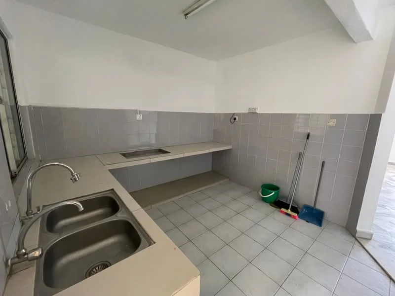 Kitchen features: double-bowl stainless-steel sink, chrome pull-down faucet, grey tiled walls, light grey tiled flooring, countertop with integrated sink, wall-mounted cabinets, open shelving, cleaning supplies visible, window for natural light, fluorescent ceiling light.