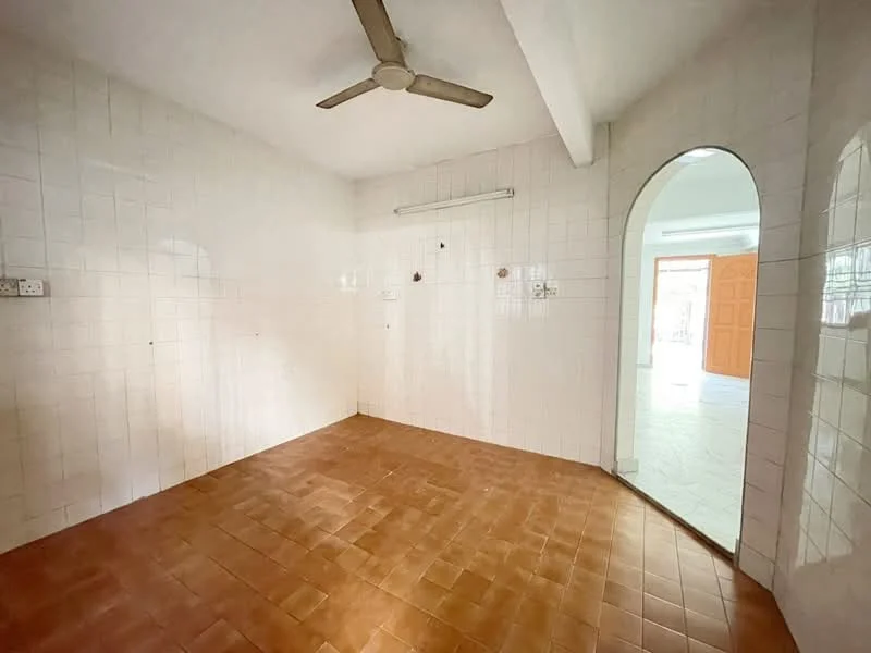 Room features: white tiled walls, brown tiled flooring, ceiling fan, arched doorway, light source from adjacent room.