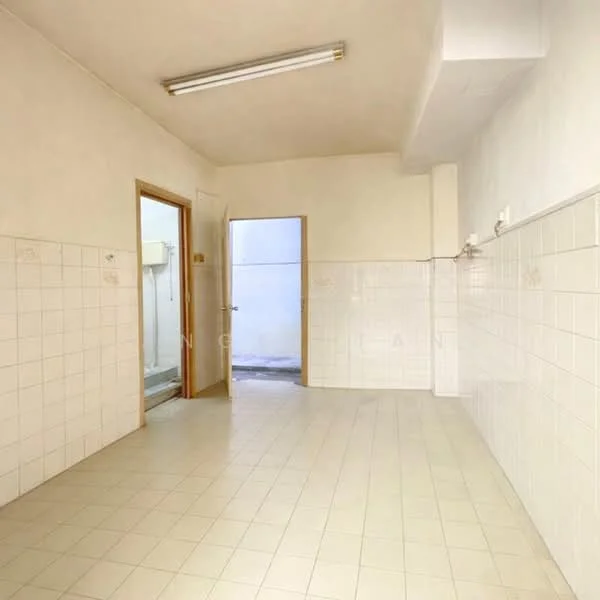 Room features: white tiled walls, cream tiled flooring, fluorescent ceiling lights, doorway leading to another room, doorway leading outside, no visible appliances, no visible furniture, empty space.