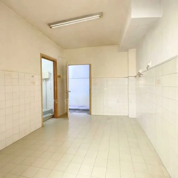Room features: white painted walls, white tiled flooring, fluorescent ceiling lights, door leading to another room, door leading outside, wall-mounted fixtures, empty space, no visible furniture.