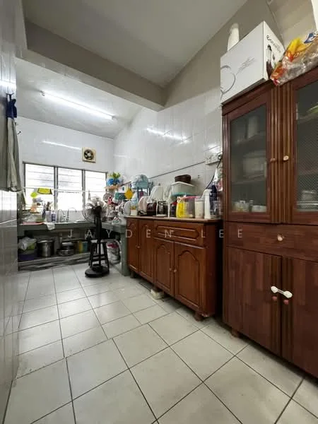 Kitchen features: white tiled walls, grey tiled flooring, wooden cabinetry, glass-front upper cabinets, stainless-steel sink, chrome faucet, kitchen countertop, various kitchen appliances, open shelving, window with metal grill, stool, wall-mounted clock.