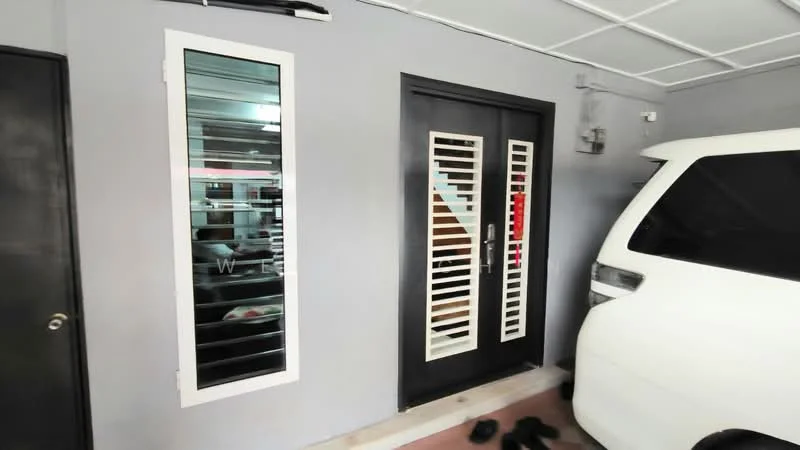 Exterior features: grey painted facade, black front door with vertical slats, side window with horizontal slats, white vehicle parked, concrete flooring, interior visible through window, door handle, shoe mat at entrance; style: modern.