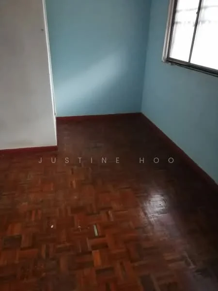 Room features: blue painted walls, parquet wood flooring, window with curtain, baseboard trim, corner of room visible, natural light from window.