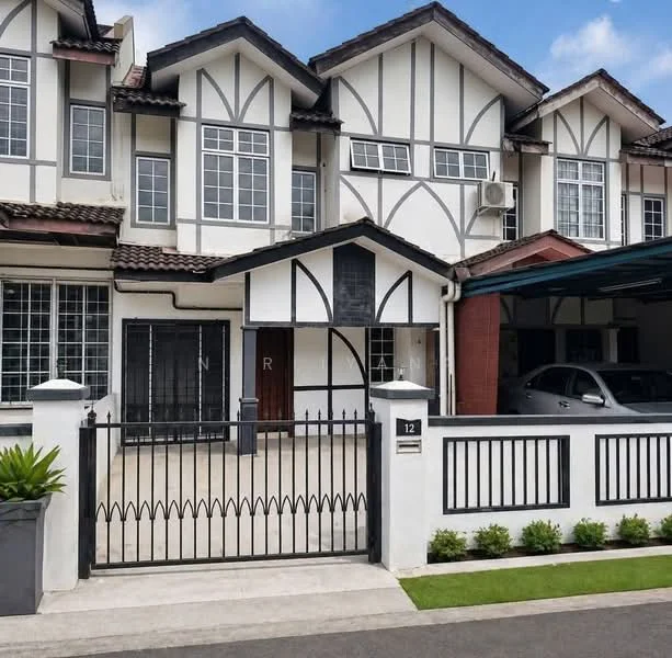 Exterior type: linked terrace house; features: white painted facade with black timber accents, gabled roof, double-storey structure, wrought iron gate, paved driveway, car porch with awning, manicured lawn, landscaped garden beds, window grilles, front porch area, decorative wall with house number; style: traditional.